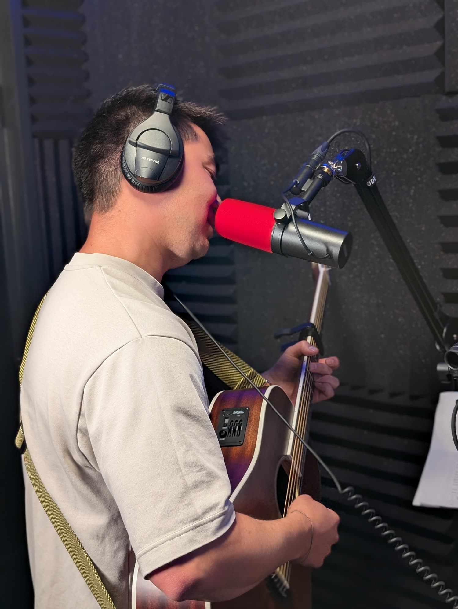 A person recording electric guitar at an Audio House studio